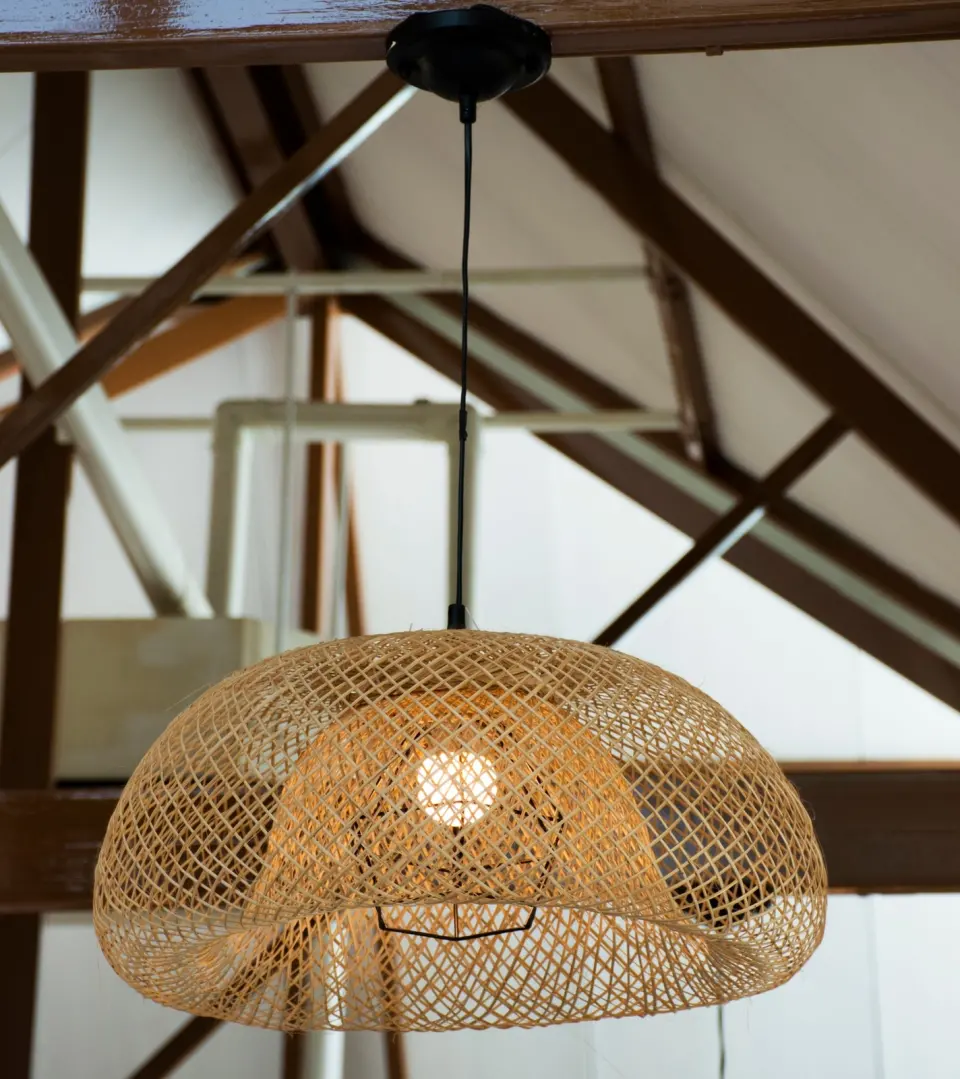 Pletena lampa od bambusa ispod drvenih greda